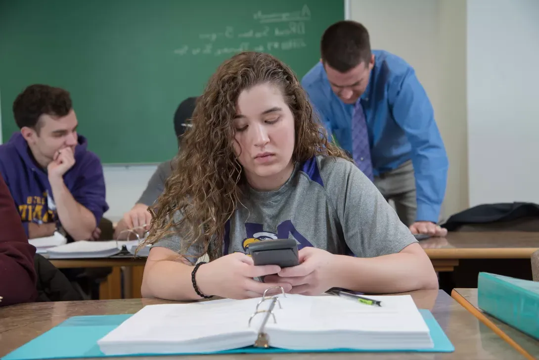 Student in math class using a calculator